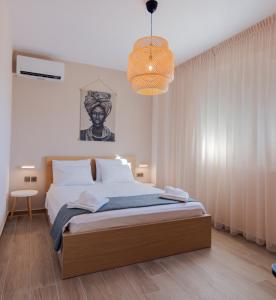 a bedroom with a bed and a chandelier at La Marine Apartments in Kalandra