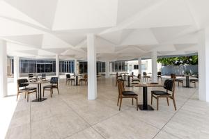 ein Speisesaal mit Tischen und Stühlen in einem Gebäude in der Unterkunft Seen Ran Hotel Bouake in Bouaké