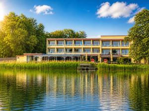 a building next to a body of water at Seehotel Schwanenhof in Mölln
