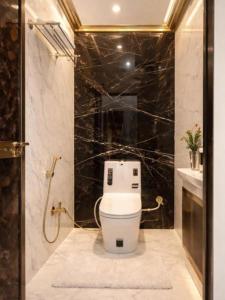 a bathroom with a toilet and a black marble wall at Royal Awadh Inn in Ayodhya +20 photos