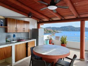 a kitchen with a table and a view of the ocean at la vista the view in Zihuatanejo