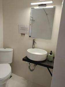 a bathroom with a sink and a toilet and a mirror at Themistoklis house in Koropi +15 photos
