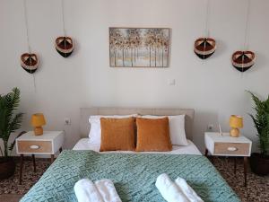 a bedroom with a bed with orange pillows and plants at Themistoklis house in Koropi
