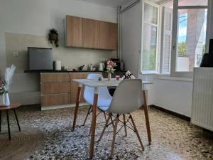 a kitchen with a white table and two chairs at Themistoklis house in Koropi