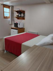 a hotel room with a bed and a microwave at Morada Bem Me Quer in Canela