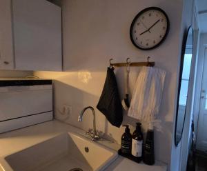 a kitchen with a sink and a clock on the wall at Eric the Red Guesthouse in Reykjavík