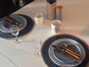 a table with two plates and wine glasses at Villa Horizon in Nice