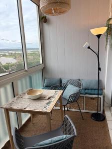 a table and chairs in a room with windows at Au clair soleil in Frontignan