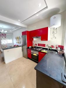 a kitchen with red cabinets and a black counter top at Visit Chamal - Horizon View in Oued Laou