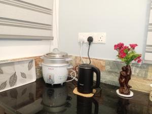 a coffee maker on a counter next to a phone at Hidden Pearl in Kandy