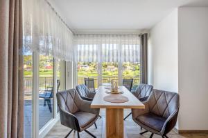 a dining room with a table and chairs and a large window at Ferienwohnung Elbufer 3a in Stadt Wehlen