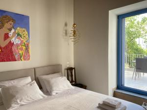 a bedroom with a bed and a painting on the wall at Hercules Historic Apartments in Chalkida