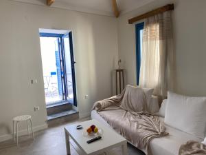 a living room with a white couch and a table at Hercules Historic Apartments in Chalkida