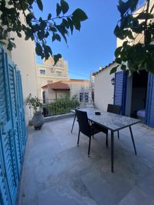 a table and a chair on a patio at Hercules Historic Apartments in Chalkida