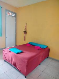 a bedroom with a red bed in a room at Casa das Hortas in São Luís