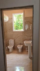 a bathroom with two toilets and a sink and a window at Sol Apartments in Durrës +118 photos