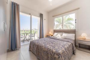 a bedroom with a bed and a large window at Lemon Tree Villa in Paralimni