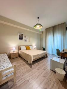 a bedroom with a large bed and a table at Favola Guesthouse Affittacamere in Nettuno