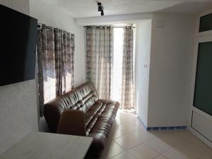 a living room with a leather couch in front of a window at Baywatch Apartmans in Brca