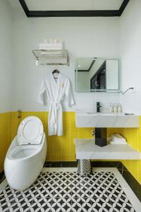 a bathroom with a toilet and a sink and a mirror at De Stefano Coffee and Hotel in Phú Quốc
