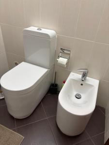 a bathroom with a white toilet and a sink at T2 A 150 m de la plage in Armação de Pêra +48 photos