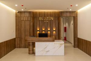 a lobby with a desk with a sign on a wall at Bluzen Hotel in Danang