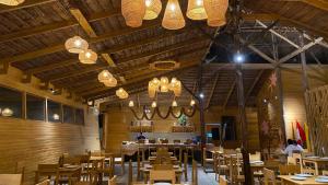 a dining room with tables and chairs and chandeliers at Hotel Amazon by On Vacation in Leticia