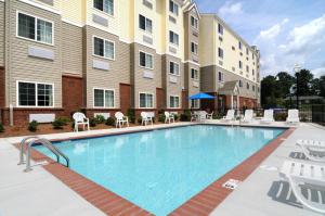 a large swimming pool in front of a building at Microtel Inn & Suites by Wyndham Columbus Near Fort Benning in Columbus