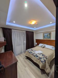 a bedroom with a bed and a desk in it at Hotel Milán in Cuenca