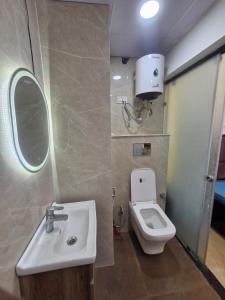 a bathroom with a sink and a toilet at The Happy Nook Stays in Winsten Park Knowledge Park V in Noida +13 photos