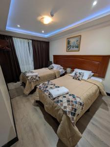 a hotel room with two beds in a room at Hotel Milán in Cuenca