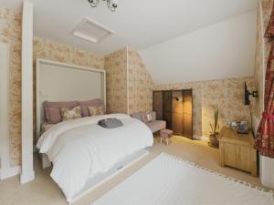 a bedroom with a large white bed and floral wallpaper at The Archway Suite in Peebles