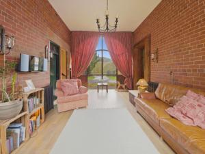 a living room with a couch and a brick wall at The Archway Suite in Peebles
