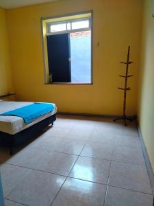 a bedroom with a bed and a window at Casa das Hortas in São Luís +1 photo