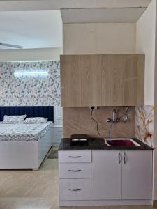 a kitchen with two beds and a sink in a room at The Happy Nook Stays in Winsten Park Knowledge Park V in Noida