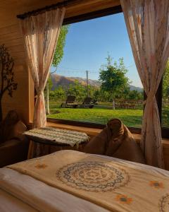 a bedroom with a window with a view of a field at Caravanà Resort in Yeghegnadzor
