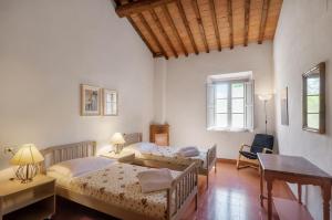 a bedroom with two beds and a desk at Fattoria La Striscia in Gambassi Terme +94 photos