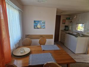 a dining room with a table and a kitchen at Mobilheim am Hafen in Gager