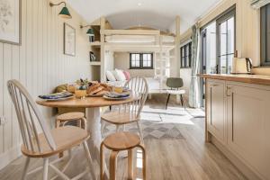 a kitchen and dining room with a table and chairs at Bankhead Shepherds Hut in Stirling +19 photos
