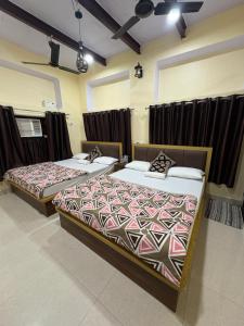two beds sitting in a room with curtains at Stay in Someshwar in Varanasi