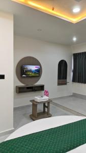 a living room with a table and a tv at Hotel Fortune in Ankleshwar +27 photos