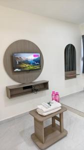 a living room with a tv on a wall at Hotel Fortune in Ankleshwar