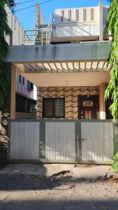 a house with a fence in front of a building at Umashankar Homestay in Nashik