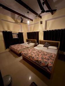 two beds in a hotel room at Stay in Someshwar in Varanasi