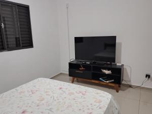 a bedroom with a flat screen tv and a bed at Recanto do Tião in Itapira
