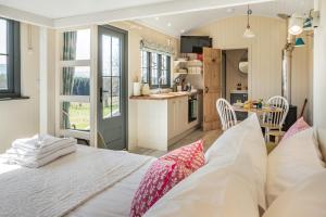 a bedroom with a large bed and a kitchen at Bankhead Shepherds Hut in Stirling