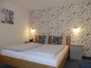 a bedroom with a bed and a wall with a wallpaper at Hotel Bellevue in Hameln