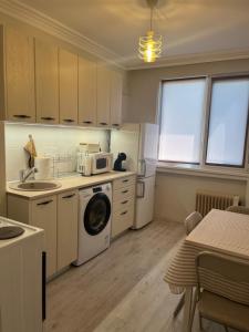 a kitchen with a washing machine and a microwave at Apartment Tzankov in Vidin