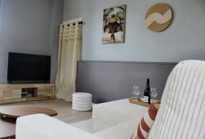 a living room with a couch and a flat screen tv at Maison de charme in Bourgueil