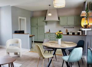 a kitchen with green cabinets and a table and chairs at Maison de charme in Bourgueil